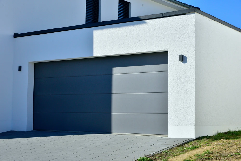 Garage de voiture moderne avec porte automatique devant un immeuble résidentiel