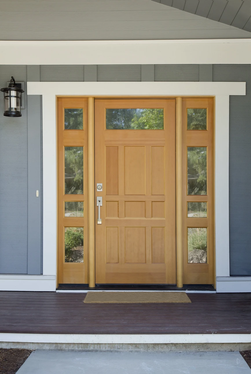 Fermeture de la porte d'entrée en bois d'une maison avec panneaux gris en journée